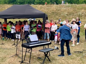 Conductor Geof Edge leads the choir at Henge Fest