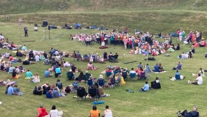 Crowds watching choirs perform at outdoor amphitheatre